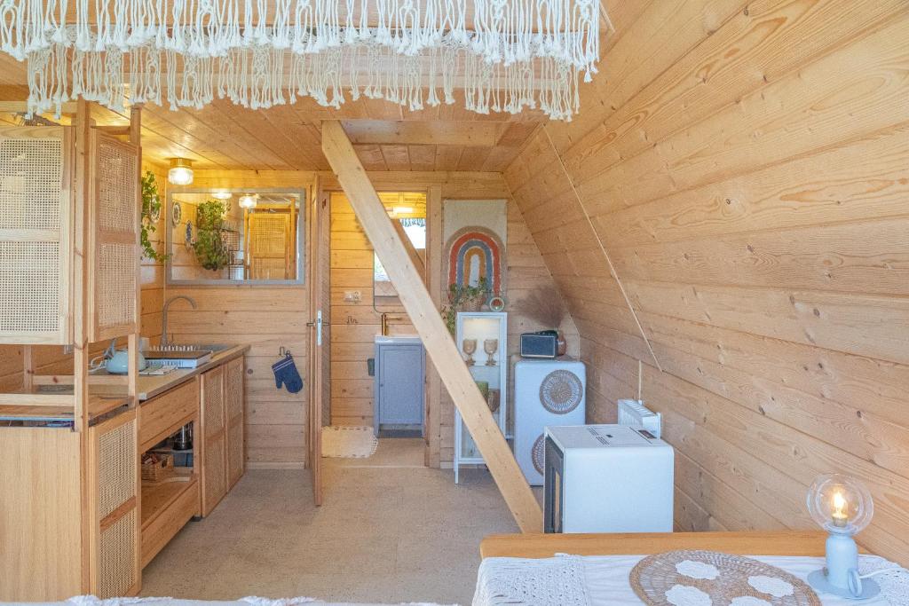 Una cabaña de madera con cocina y escalera. en Alemiło mini - domek z balią i widokiem na Babią Górę, en Zawoja