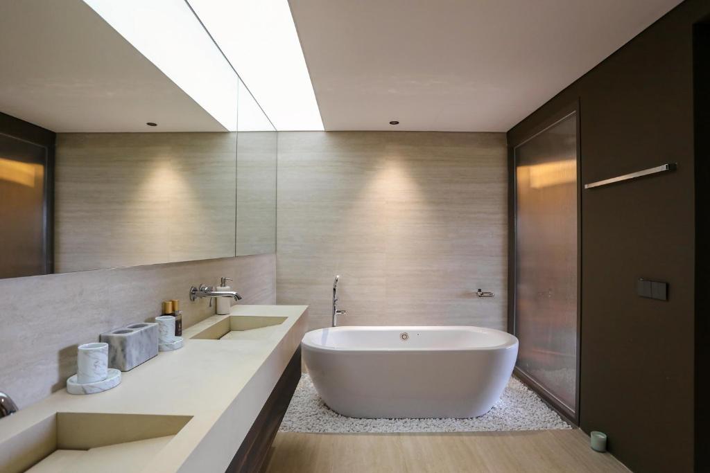 a bathroom with a large tub and a sink at The Indigo Courtyard Hanoi-Elegant Loft-Steps from Old Quarter in Hanoi