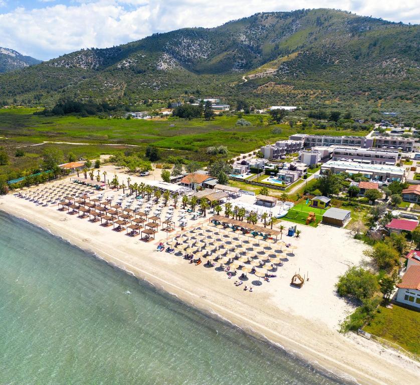 an aerial view of a beach with chairs and umbrellas at ALEA Hotel & Suites in Prinos