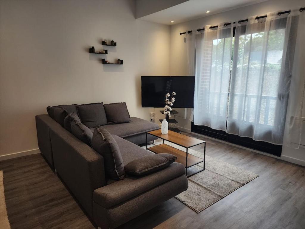 een woonkamer met een bank en een tafel bij Le Fécamp central, centre ville à 1km de la plage in Fécamp