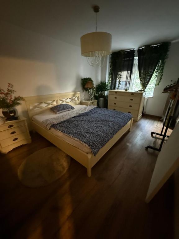 una camera da letto con un letto, pavimenti in legno e finestre di Green Apartment a Bucarest