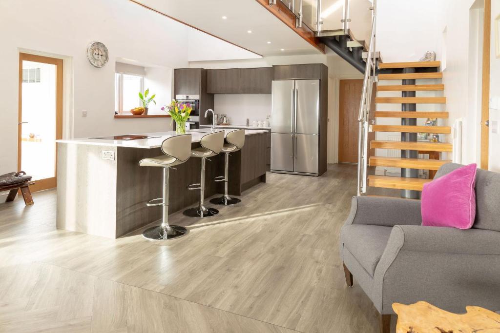a kitchen and living room with a staircase in a house at Sunset View in Innellan