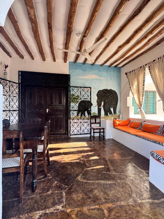 een eetkamer met een tafel en een bank bij villa luna in Watamu