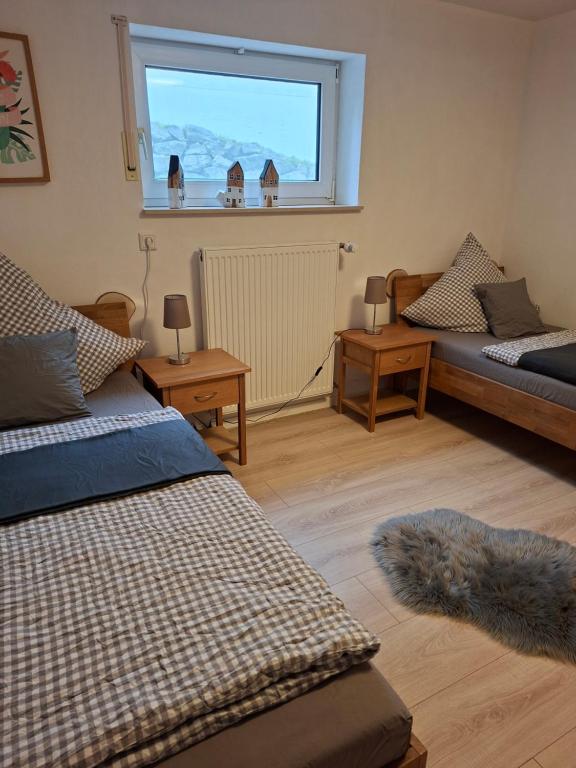 Una sala de estar con dos camas y una ventana. en Ferienhaus Weitblick, en Olsberg