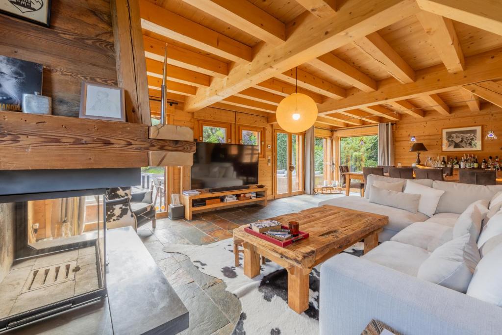 Una sala de estar con un sofá y una chimenea. en Alpine Luxury Chalet Pool & Jacuzzi, en Cordon