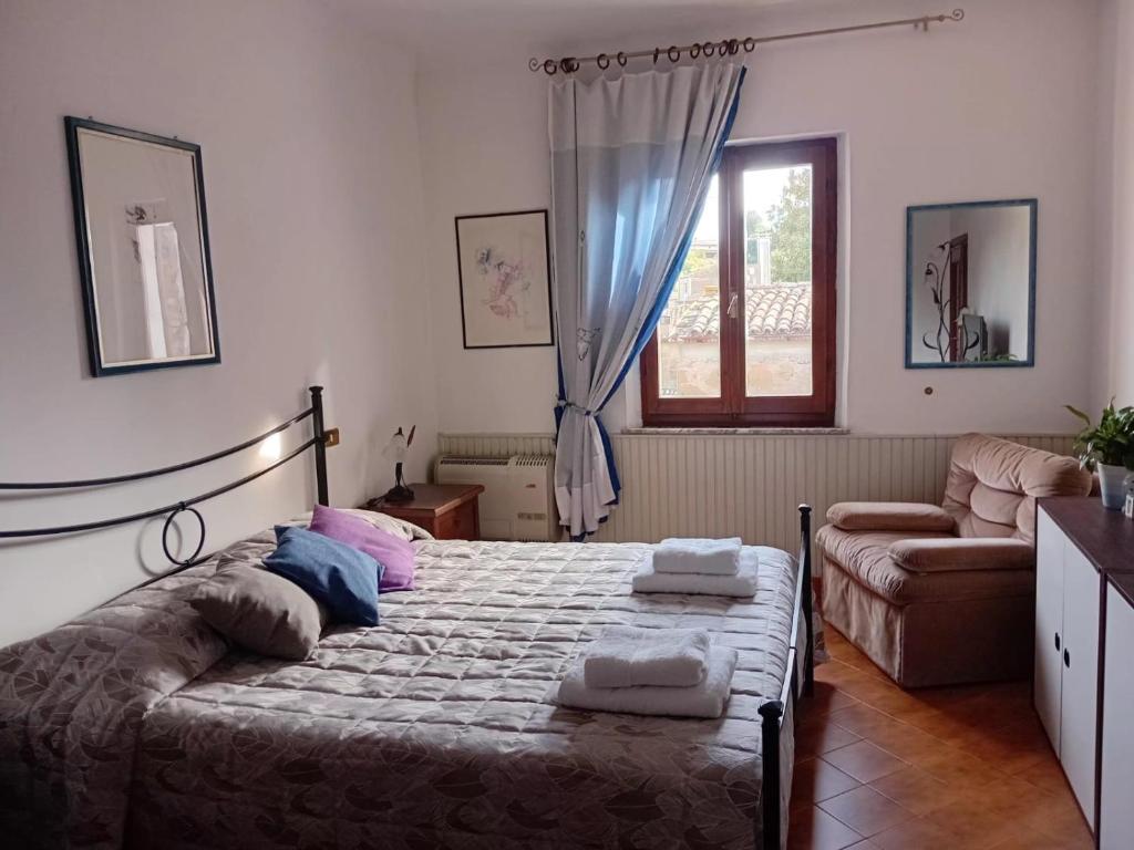a bedroom with a bed and a couch and a window at Le Scalette Casa Vacanze in Acquapendente