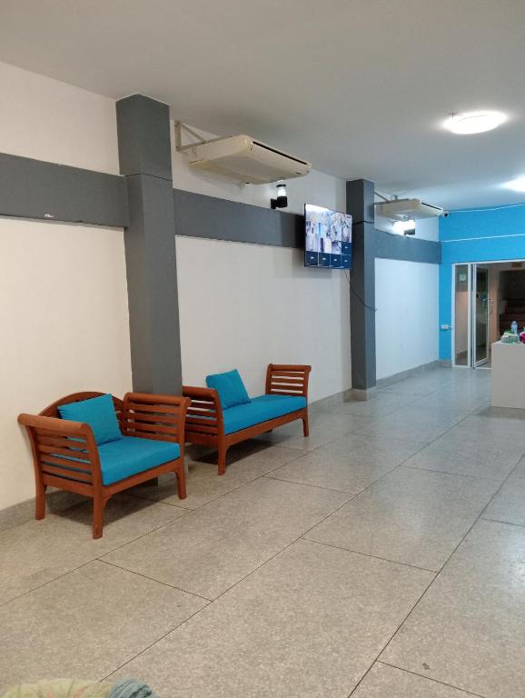 een wachtkamer met drie stoelen en een flatscreen-tv bij Italay in Krabi town