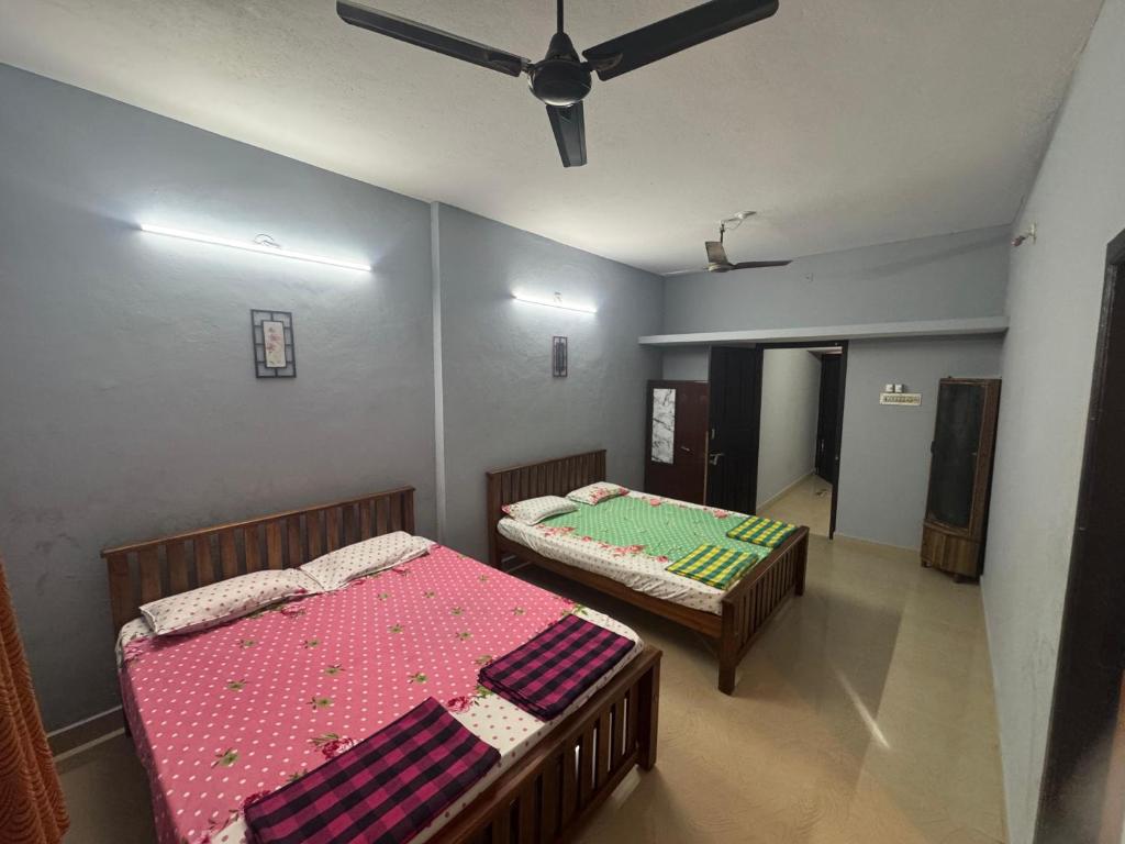 a bedroom with two beds and a ceiling fan at ROB'S INN Groupstay 