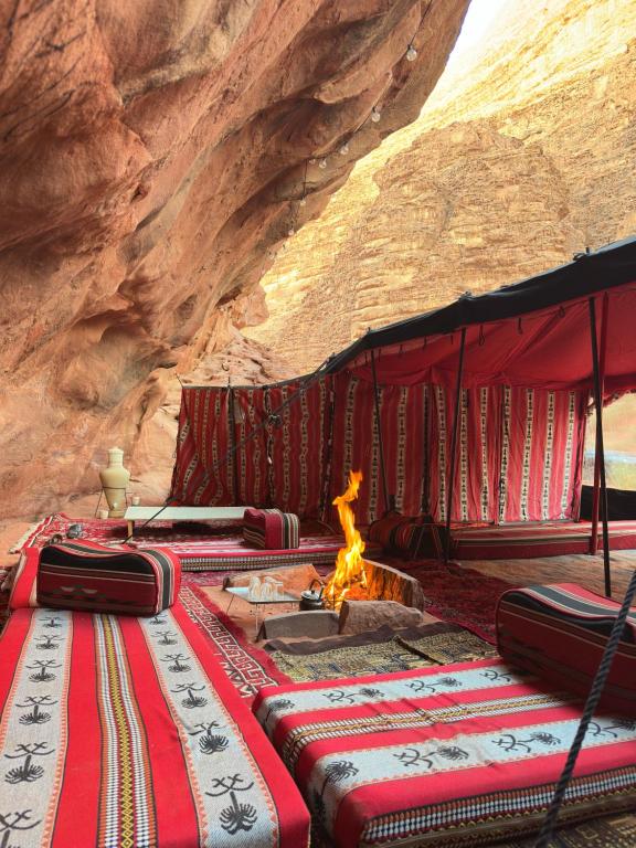 a group of tents with fires in front of a mountain at The Legacy of Wadi Rum in Wadi Rum