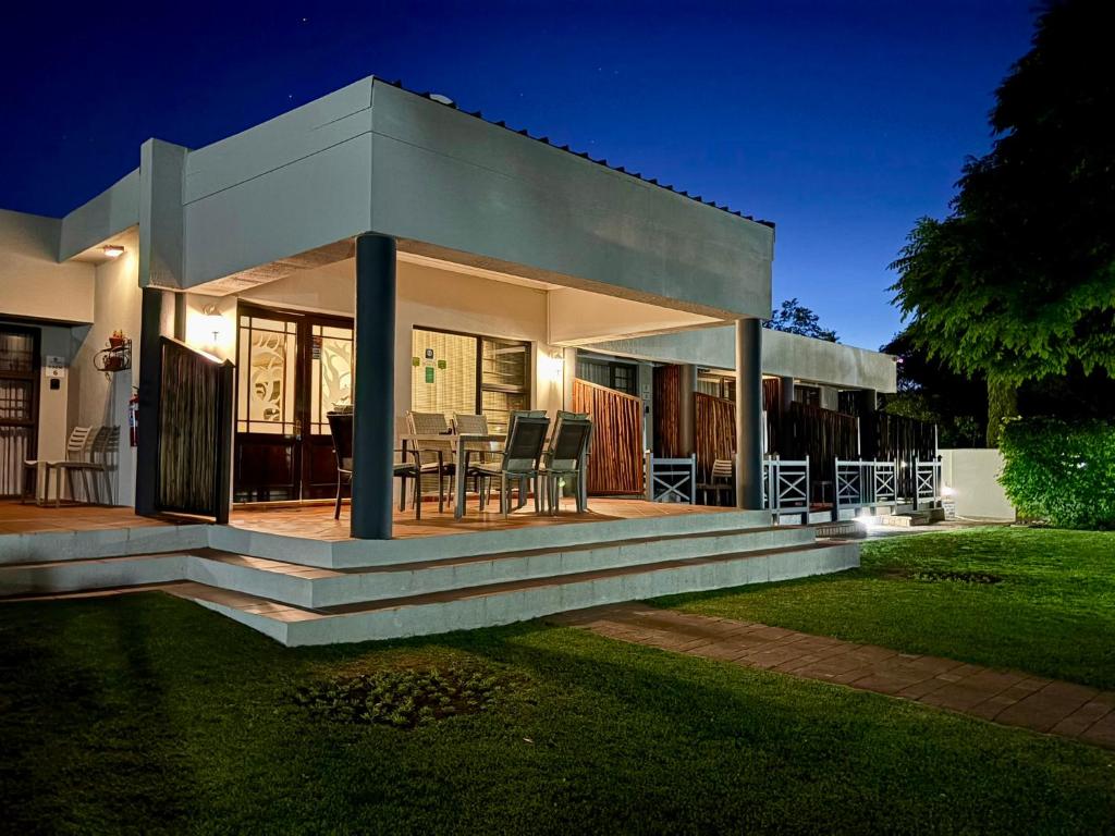 a house with a porch with a table and chairs at The Suburban Guest House in Bloemfontein