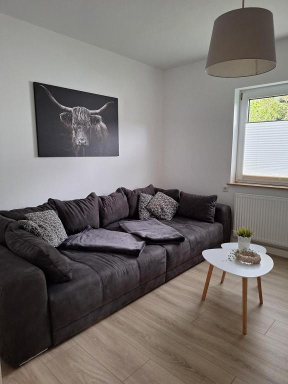 a living room with a brown couch and a table at Ferienhaus Weitblick in Olsberg