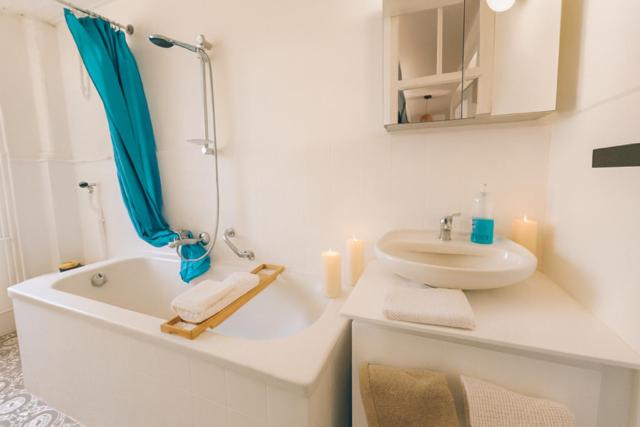 a bathroom with a tub and a sink and a mirror at Agréable 3,5 pièces situé au pied du château in Porrentruy