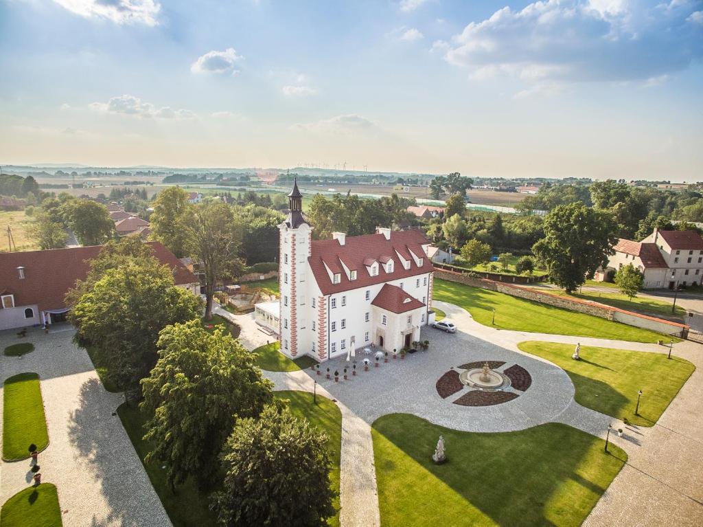 widok z powietrza na biały budynek z wieżą zegarową w obiekcie Pałac Łagów w mieście Zgorzelec