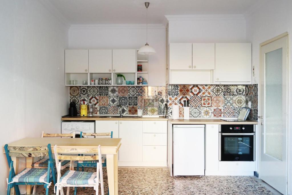 a kitchen with white cabinets and a wooden table at Holiday apartment Sombrero in Nea Peramos