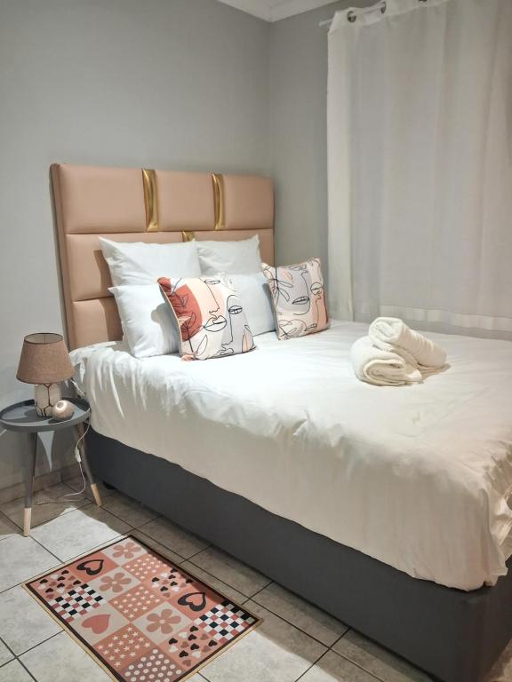 een slaapkamer met een bed met witte lakens en kussens bij TripleM comfort zone in Windhoek