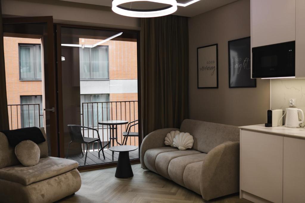ein Wohnzimmer mit Couch und Balkon in der Unterkunft Studio Gdańsk Luxury Stay in Danzig