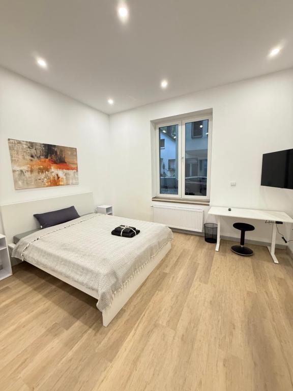 a white bedroom with a bed and a desk at Exklusives City-Zimmer, Gemeinschaftsbad und Küche in Herne