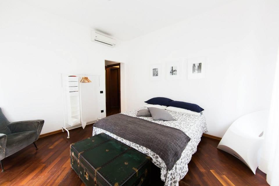 sypialnia z łóżkiem z kocem i walizką w obiekcie I Quattro Gattoni w mieście Napoli