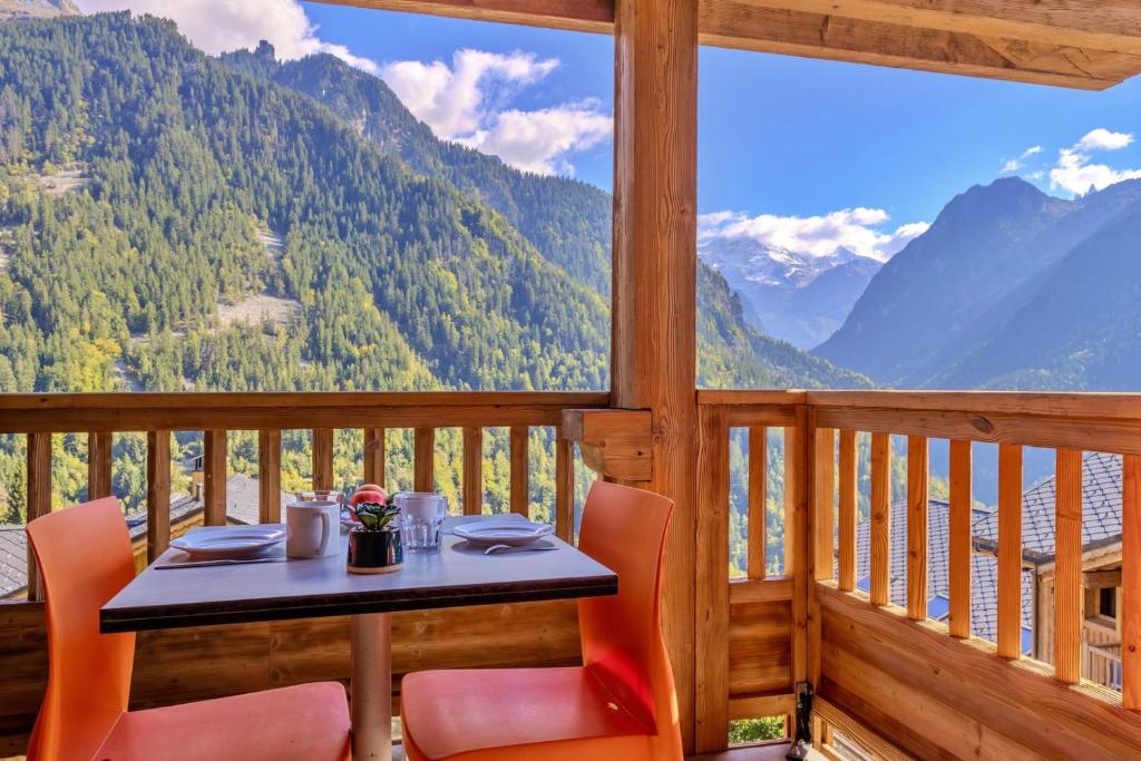 einen Tisch und Stühle auf einem Balkon mit Bergblick in der Unterkunft Rossa - ski, vue Montagne, Spa & Terrasse in Champagny-en-Vanoise