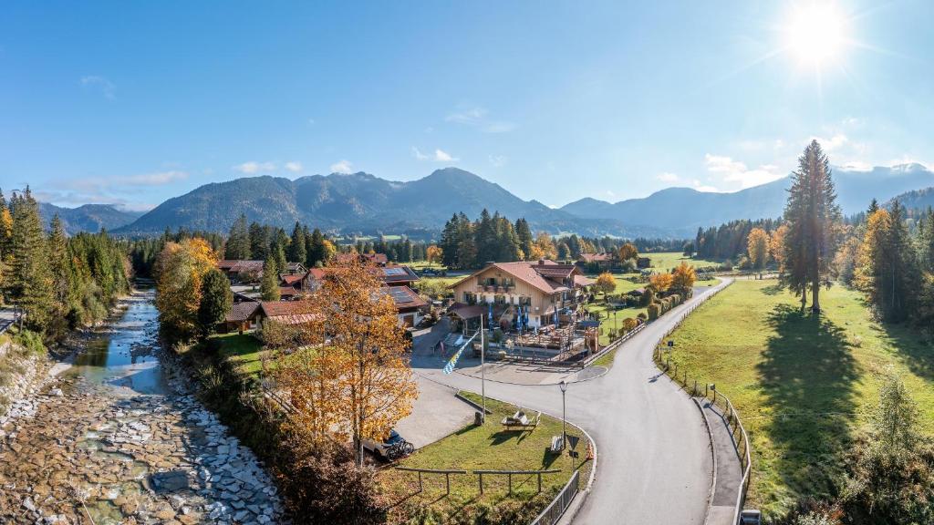 an aerial view of a resort with a river and mountains at LandererMühle in Lenggries