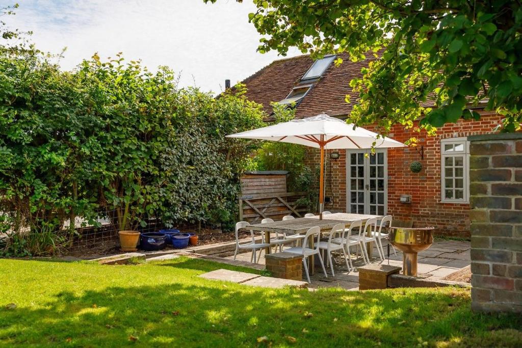 a patio with an umbrella and a table and chairs at Courtyard Cottage, Pulborough in Pulborough