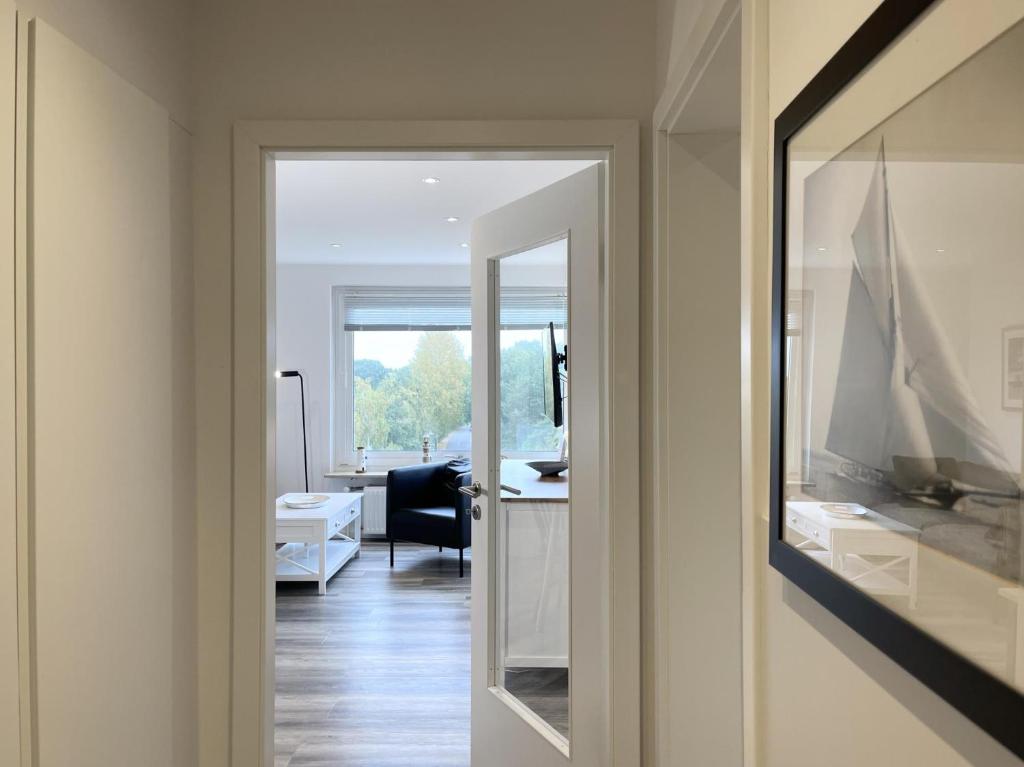 a hallway with a mirror and a room with a desk at Blankwasser 169 in Grömnitzerhagen