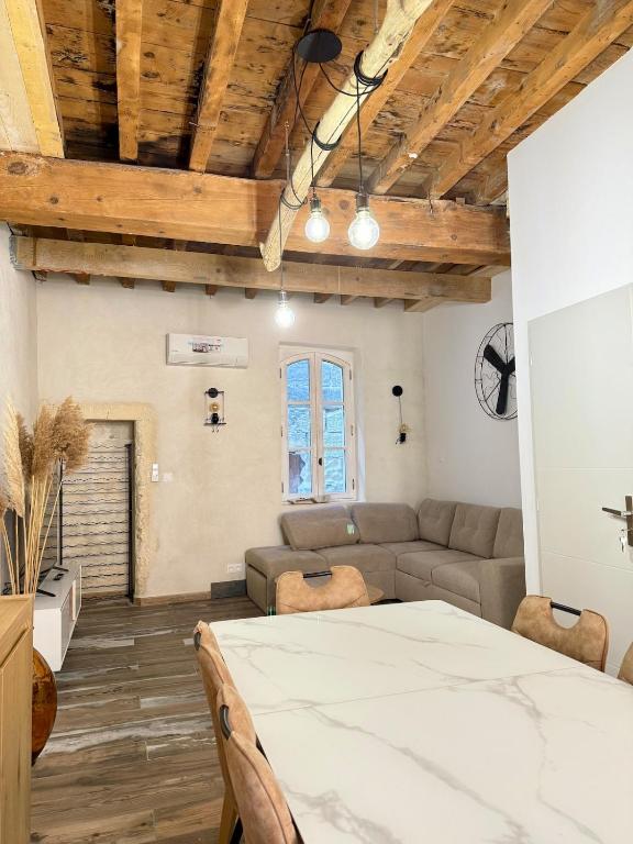 una sala de estar con un sofá y una mesa en Appartement Cosy avec balcon, en Arles