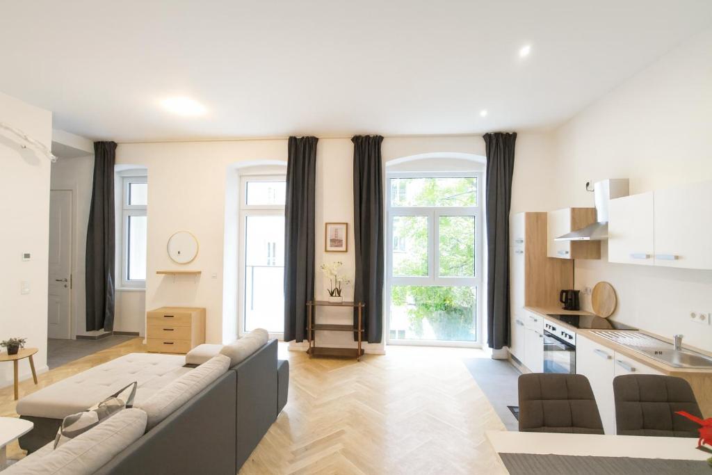 a living room with a couch and a kitchen at Céleste Suites in Vienna