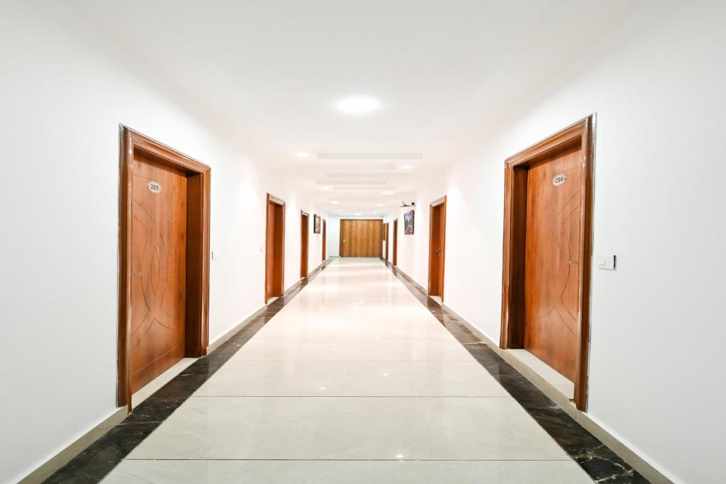 an empty corridor of an office building with wooden doors at Collection O Royal King in Rohtak
