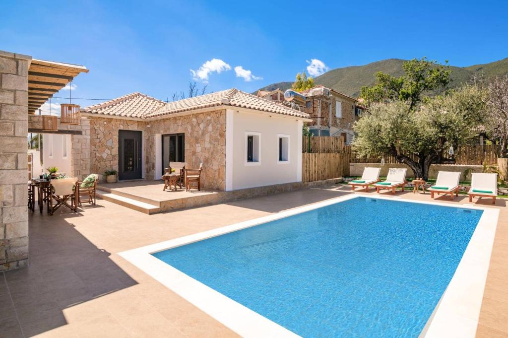 a villa with a swimming pool in front of a house at Villa Halakas by Villa Plus in Katastárion
