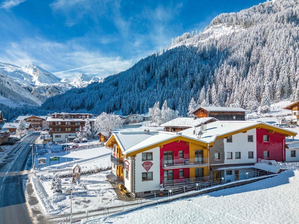 a town in the mountains with snow on the ground at Ferienwohnungen Egger in Tux