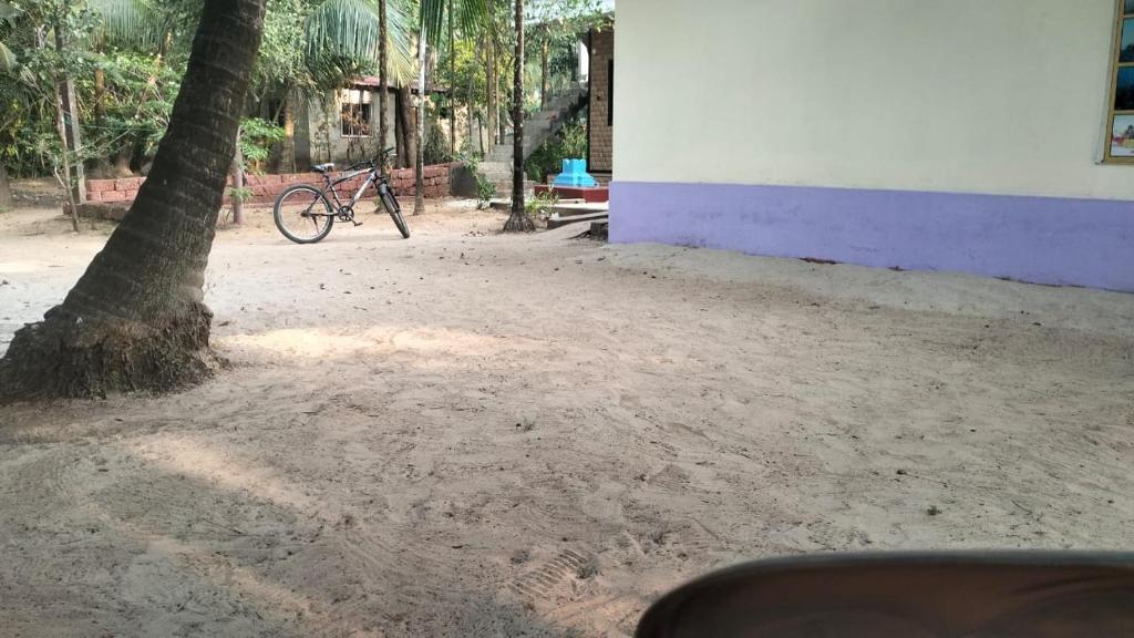 a bike parked next to a building next to a tree at Sai Homestay Tarkarli in Malvan