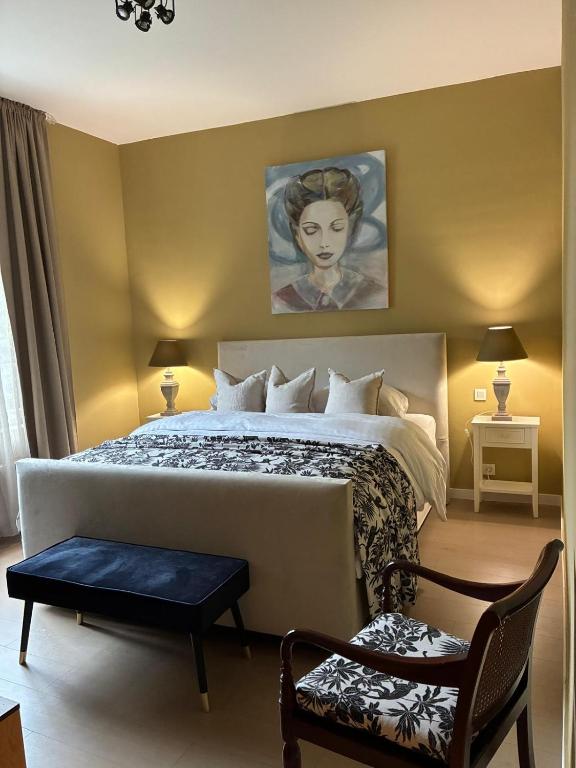 a bedroom with a bed and a portrait of a woman at Si brugge in Bruges
