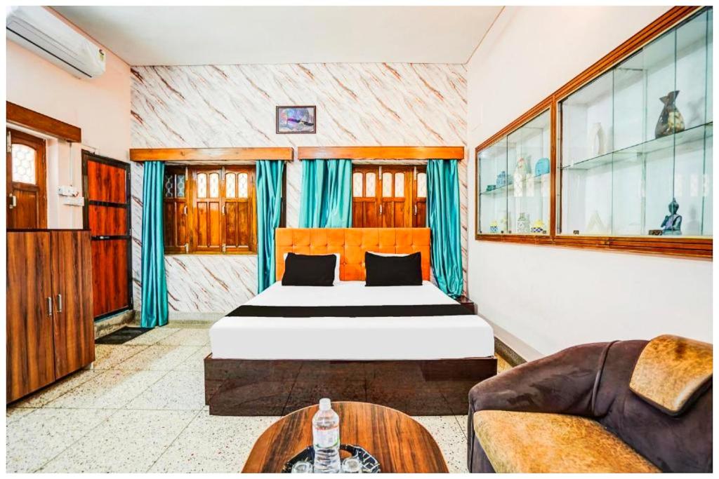 un dormitorio con una cama y un sofá en Hotel Subh Aura Suites - Near Kashi Vishwanath Temple And Ganga Ghat -With Fully Air conditioned- Wifi - Room Service - A Luxury Room in Varanasi, en Varanasi