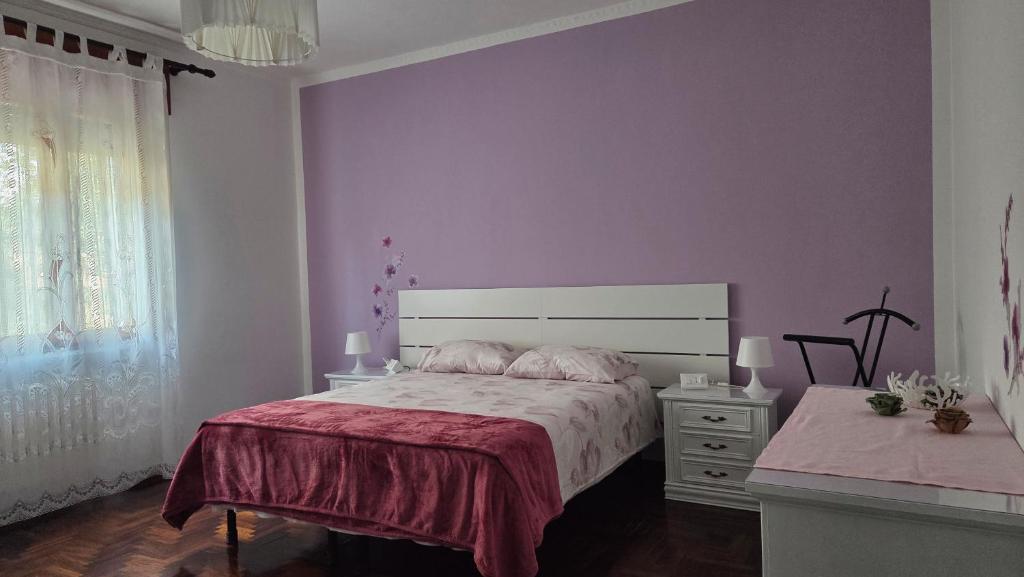 - une chambre avec des murs violets, un lit et une commode dans l'établissement Casa Kendra, à Montegrotto Terme