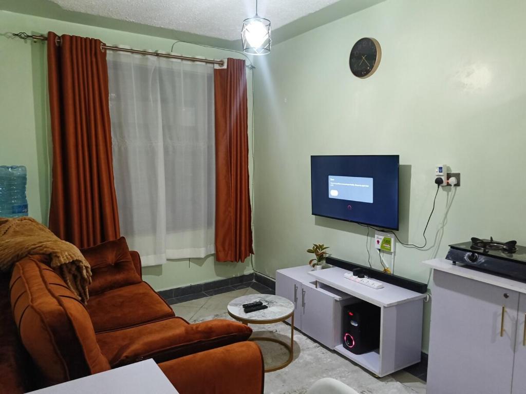 a living room with a couch and a flat screen tv at Legatus Cozy Homes Ngong in Ngong