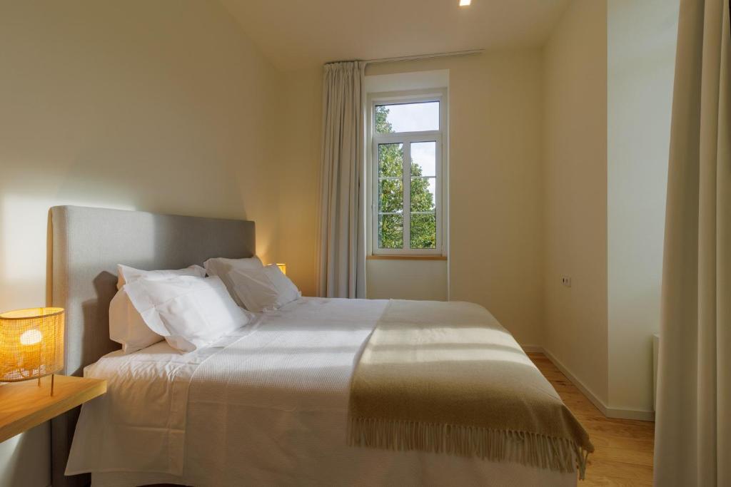 a bedroom with a large bed with a window at Quinta da Janeca in Vila Pouca de Aguiar