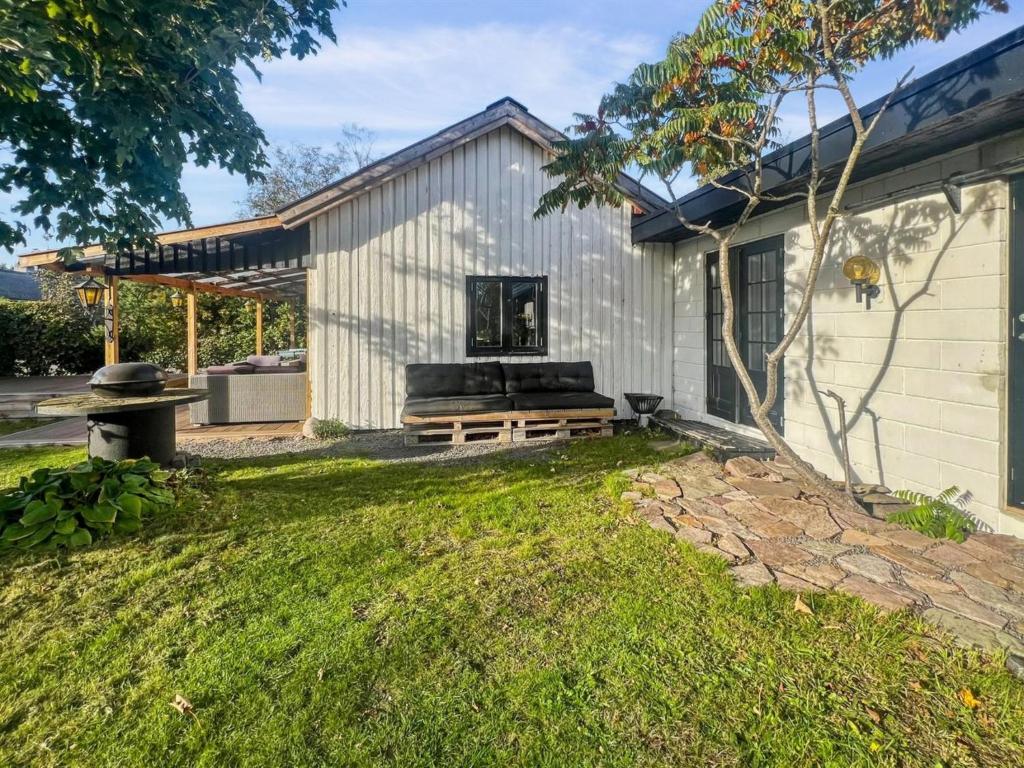 a house with a bench in the yard at Holiday Home Alica - 200m from the sea by Interhome in Neksø