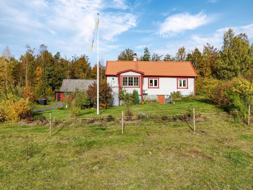a house with an orange roof in a field at Holiday Home Skjutsmåla by Interhome in Olofström