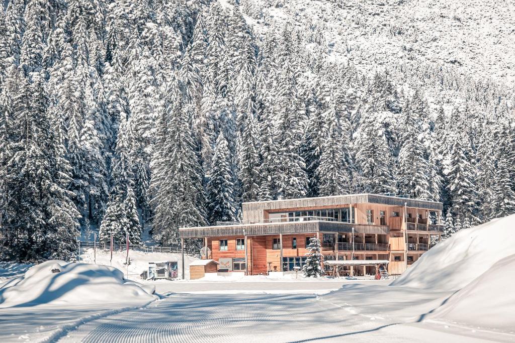 a building covered in snow in front of a mountain at Boutique Hotel LechZeit in Elmen
