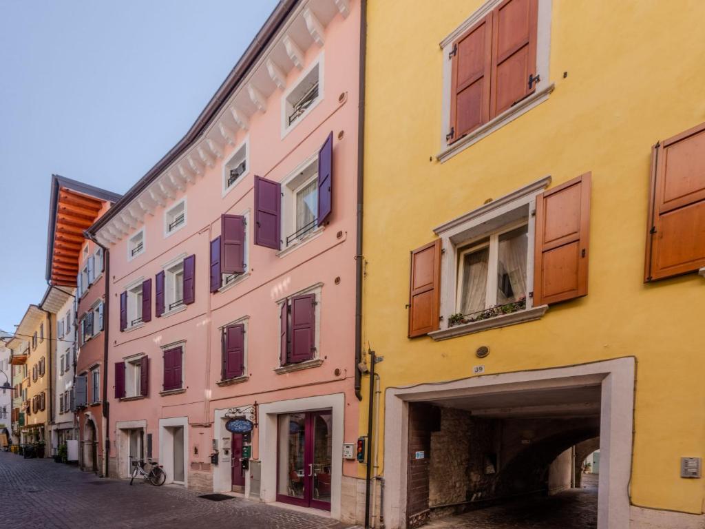un edificio giallo e rosa su una strada di Apartment Felicitahome by Interhome ad Arco