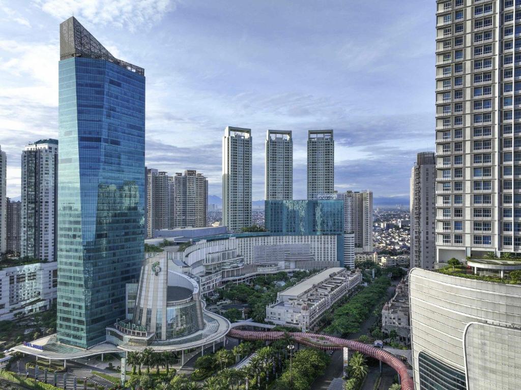 a city skyline with tall buildings and a freeway at Pullman Jakarta Central Park in Jakarta