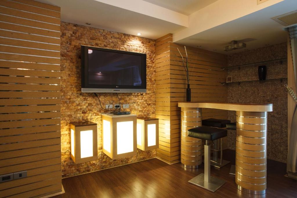 Habitación con TV en una pared de ladrillo en Harmony Living Condominium, en Makkasan