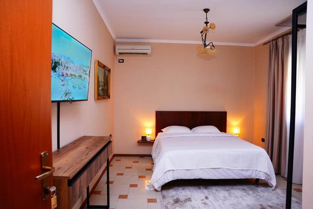 a bedroom with a bed and a flat screen tv at Vila 15 By Nam Nam Tirane in Tirana