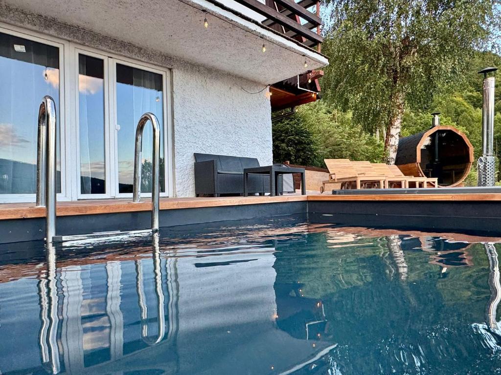 a swimming pool in front of a house at Willa Widokowa - balia, sauna, basen, bilard in Międzybrodzie Bialskie
