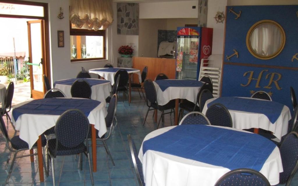 un ristorante con tavoli e sedie blu e bianchi di Albergo Riccio a Marina di Camerota