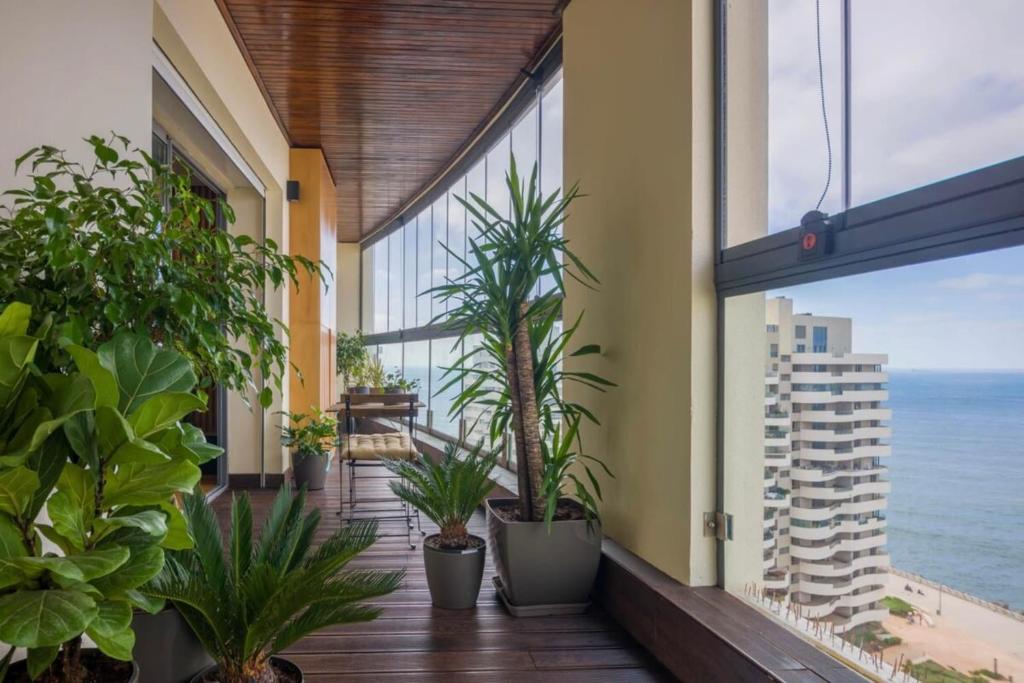 a balcony with plants and a view of the ocean at La Terrazza at Marina - By AppartAli in Casablanca-Port
