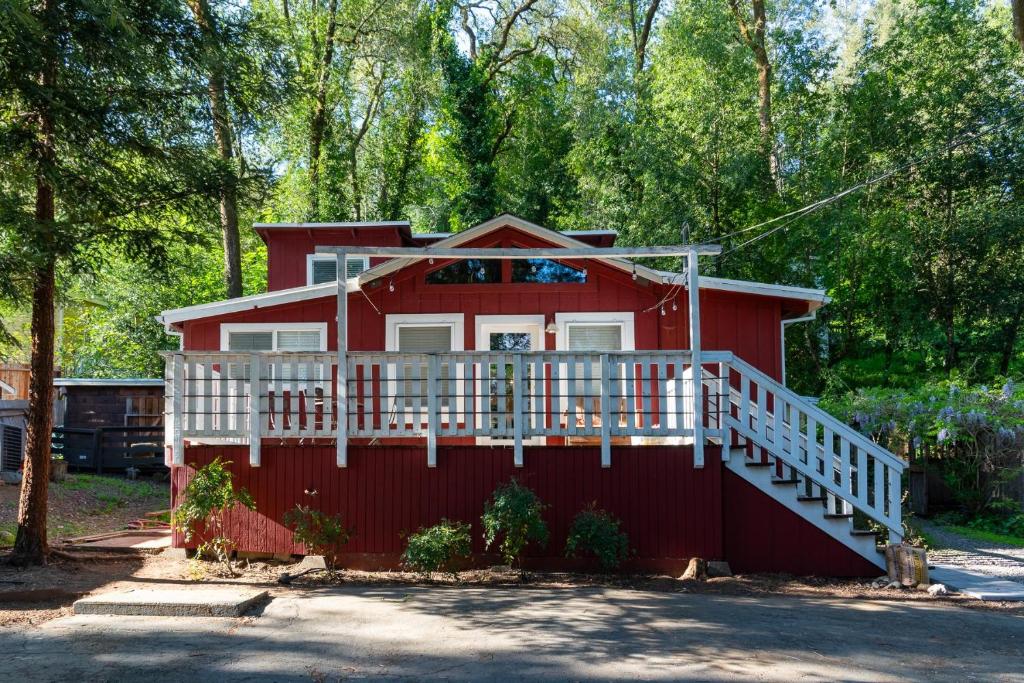 una casa roja con un porche blanco y una barandilla blanca en Riverbend Retreat A Wine Country Escape, en Healdsburg