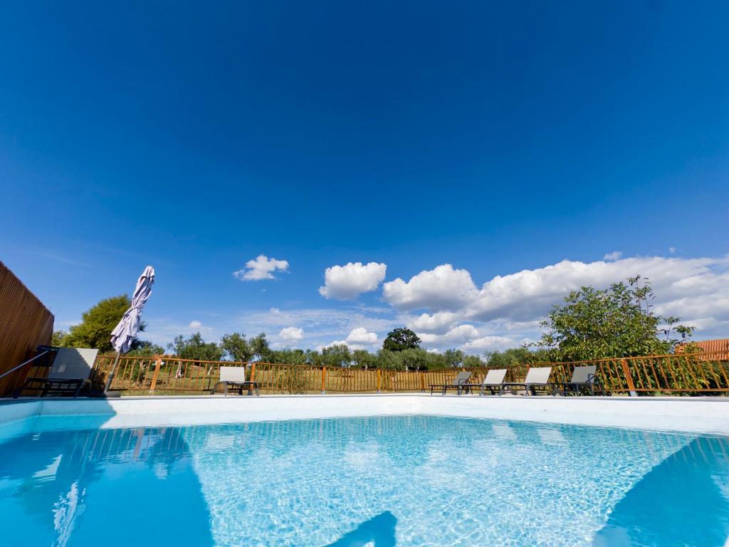 a large swimming pool with chairs and a fence at Casas Matias Nature Serra da Estrela - Alojamentos em Seia in Carragozela