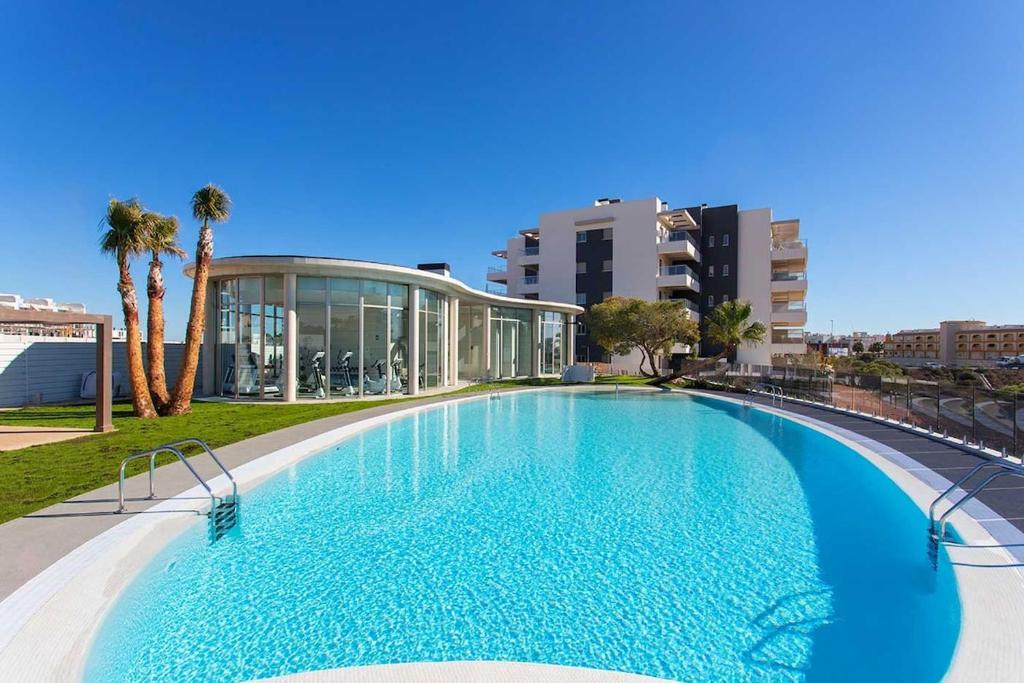 オリフエラ・コスタにあるSuperbe appartement avec spa intérieurの建物の前の大きなプール